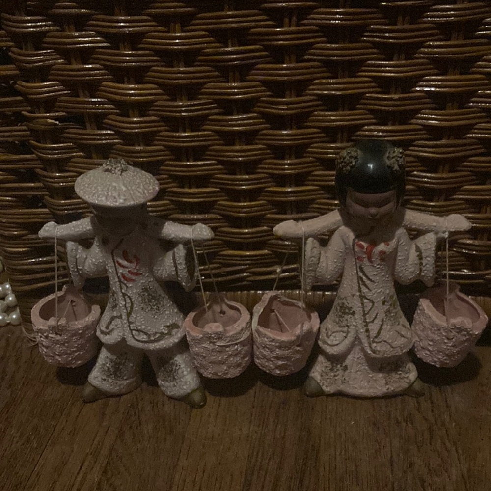 Asian couple carrying baskets statues